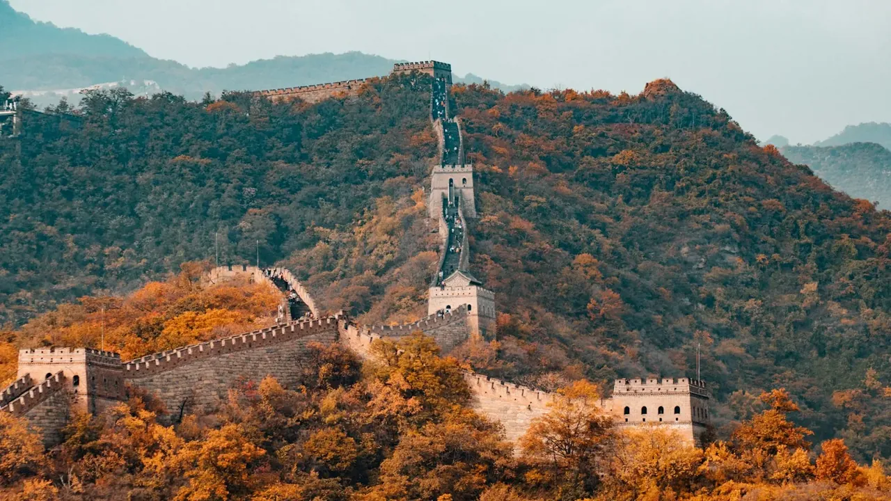 The Great Wall of China snaking over green mountains