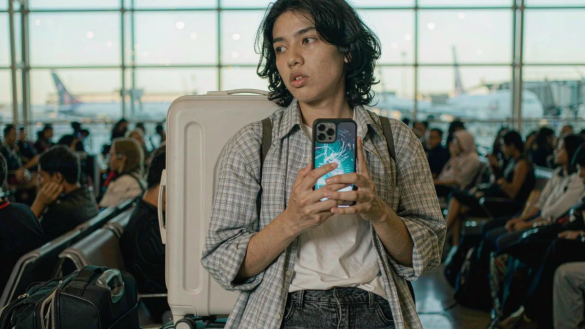 Traveler setting up an eSIM on a Galaxy phone in an airport lounge