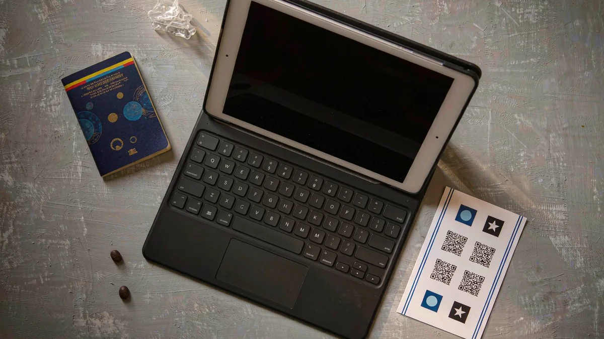 Android tablet with keyboard cover, passport and QR card flat-lay