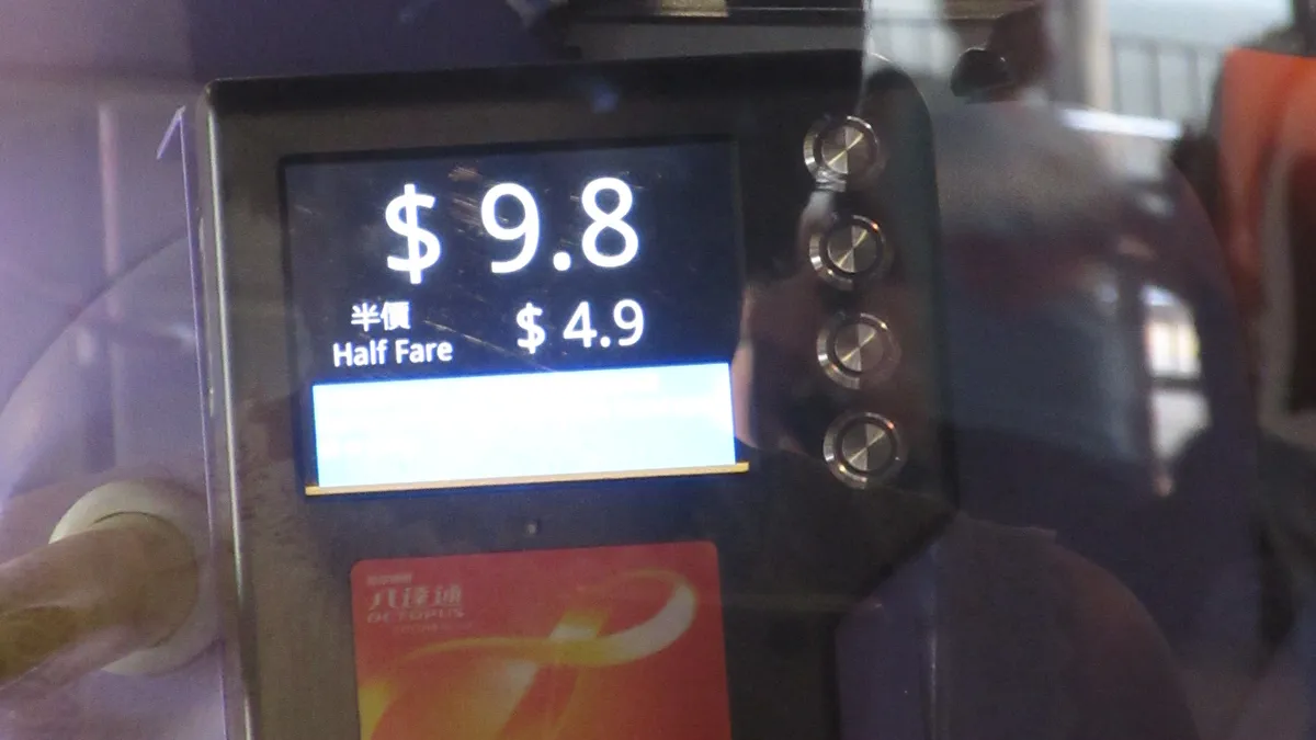Octopus card touching a bus card reader showing the HK$9.8 fare
