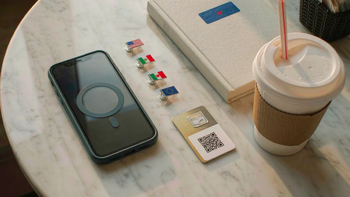 iPhone flat-lay with country flag pins and an eSIM QR code
