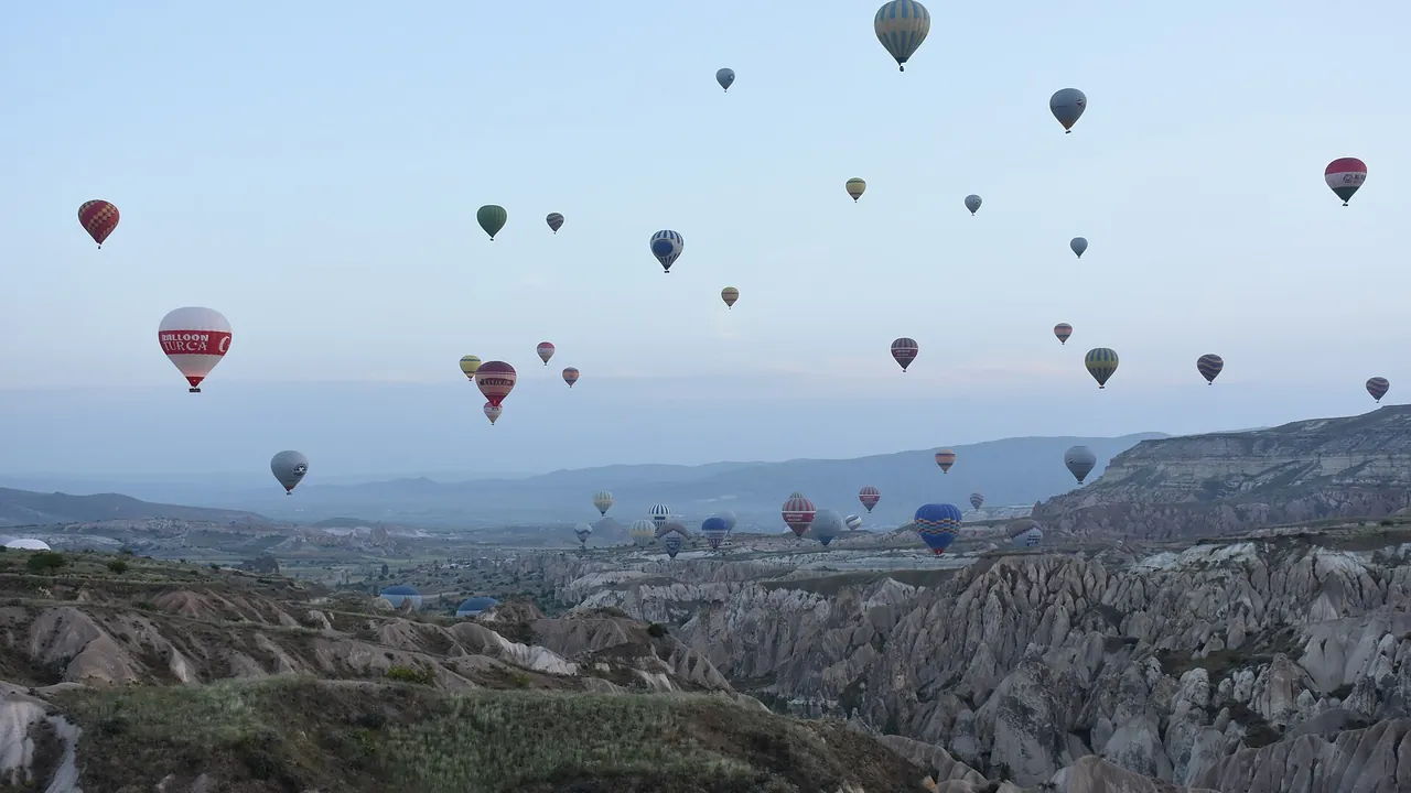 Hot air balloons drifting over the rock valleys of Cappadocia at sunrise