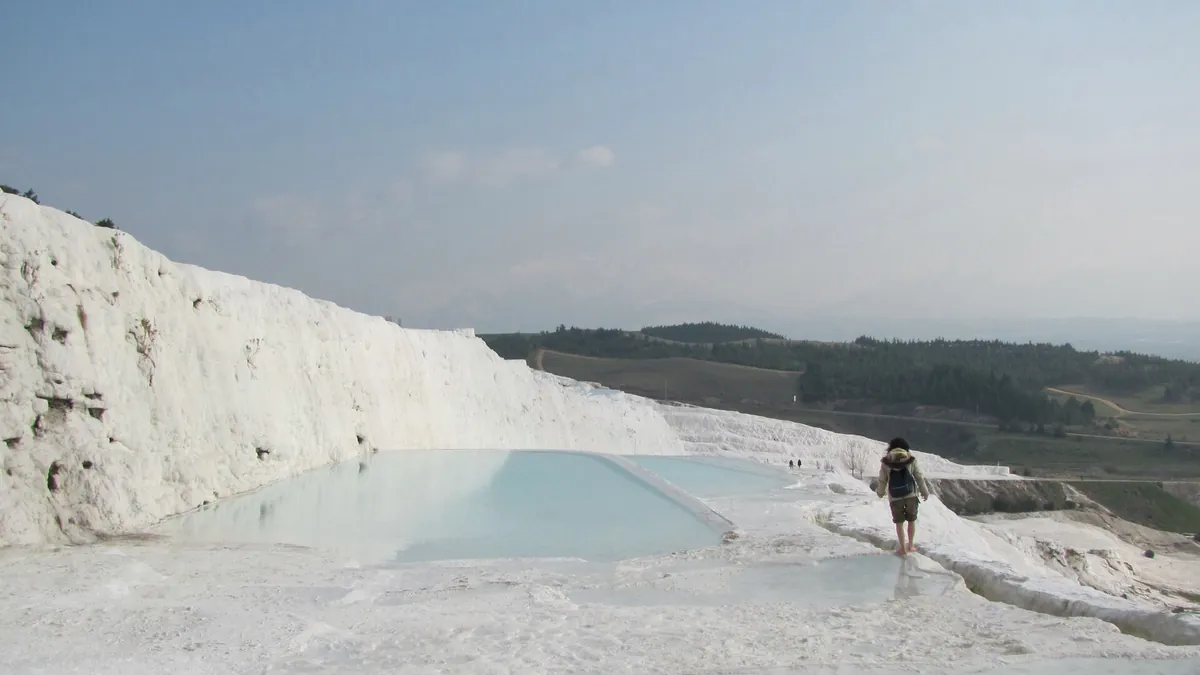 White travertine terraces of Pamukkale with visitors walking along the rim